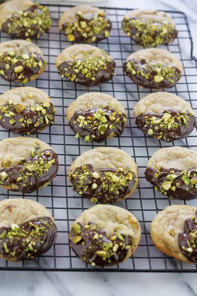 Chocolate dipped Pistachio nut cookies on a cooling rack.