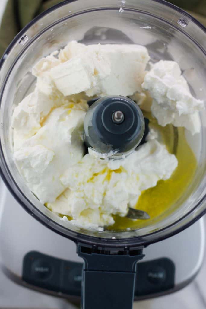 Overhead shot of ingredients for whipped feta in the bowl of the food processor.