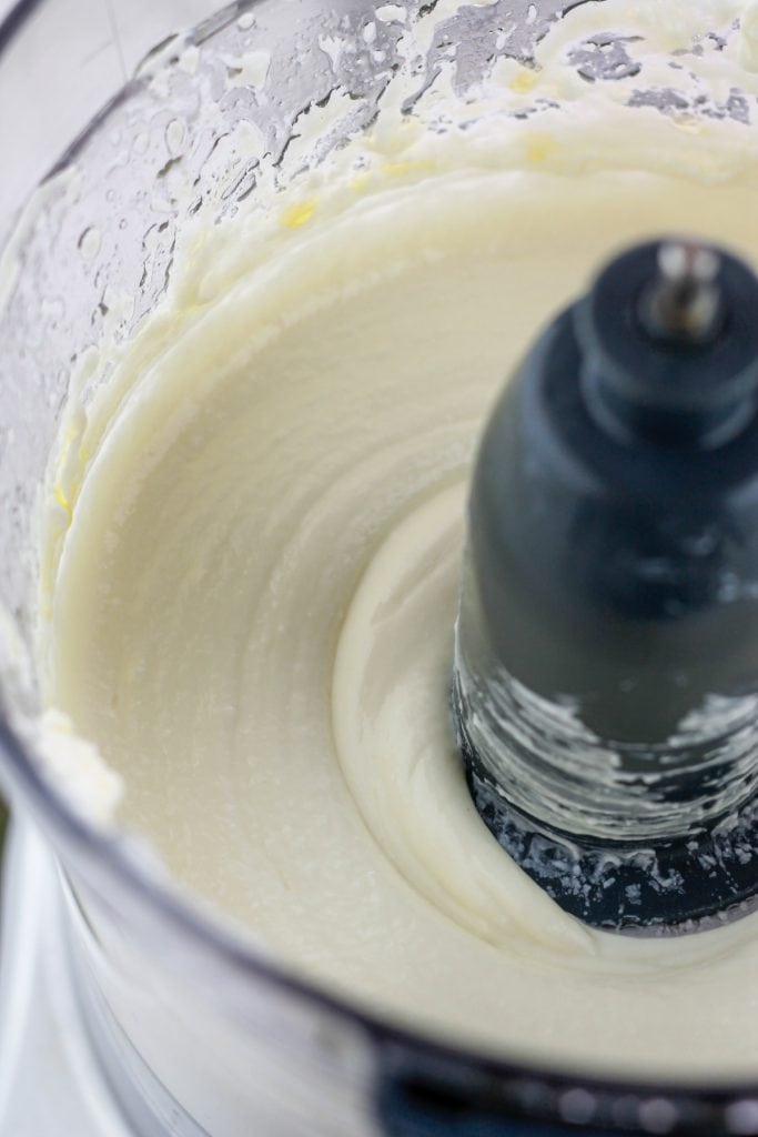 Shot of whipped feta in the bowl of a food processor.