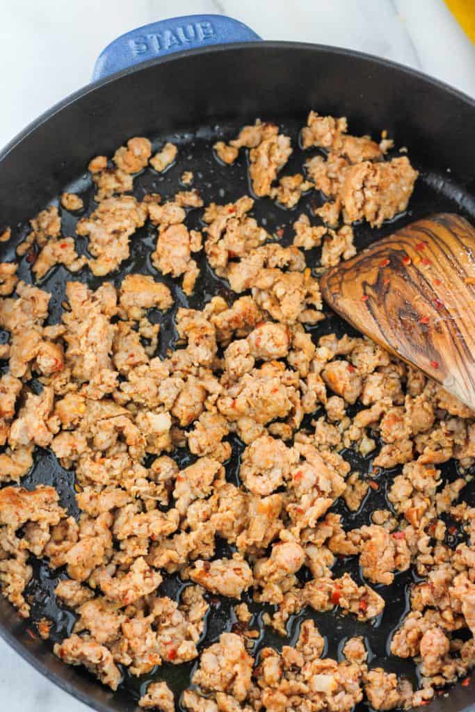 Spicy Italian sausage cooked in skillet.