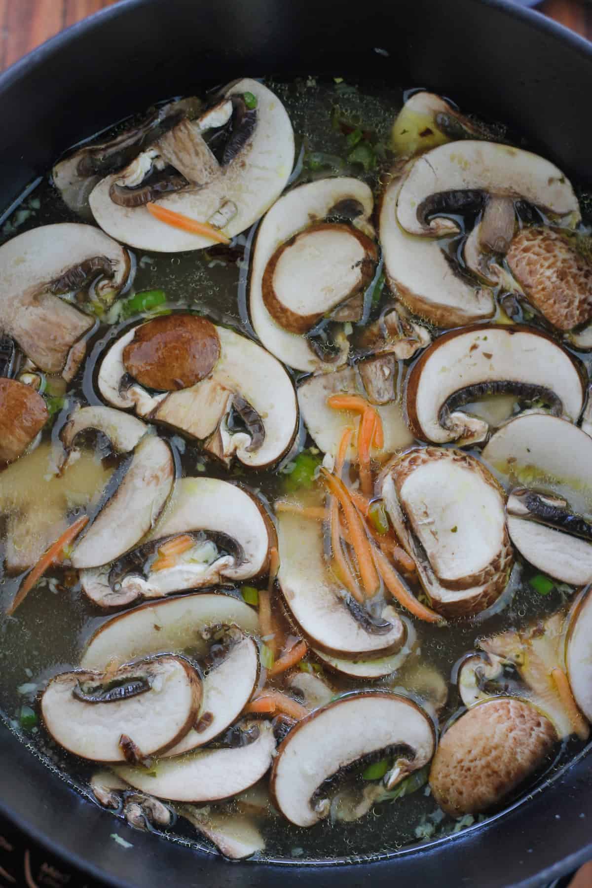 Chicken stock, carrots and mushrooms added to dutch oven.