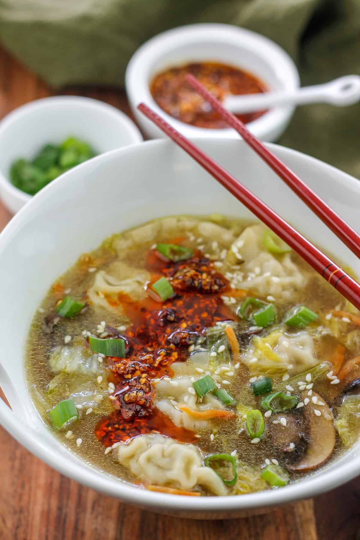 Close-up of super easy potsticker soup garnished with sesame seeds and spicy chili onion crunch.