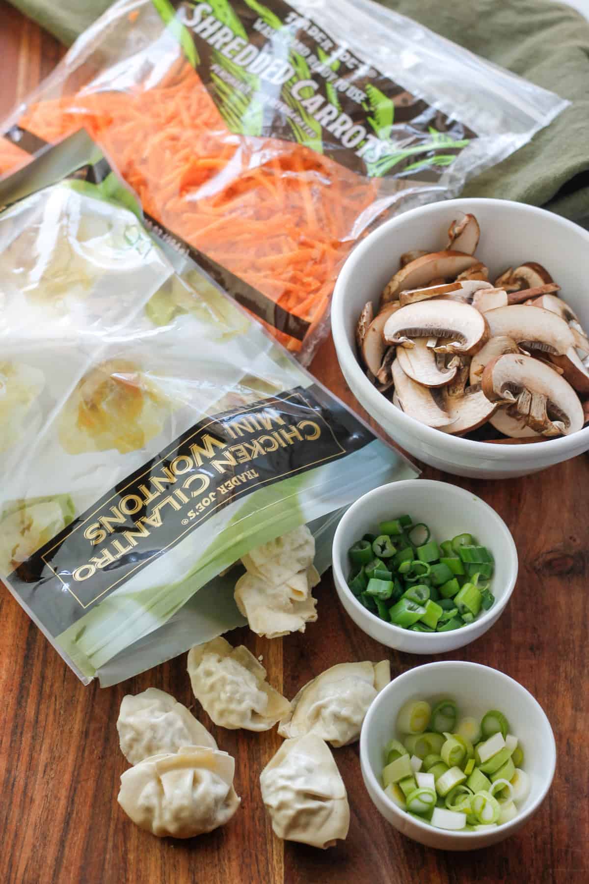 Ingredients for super easy potsticker soup on a wooden cutting board