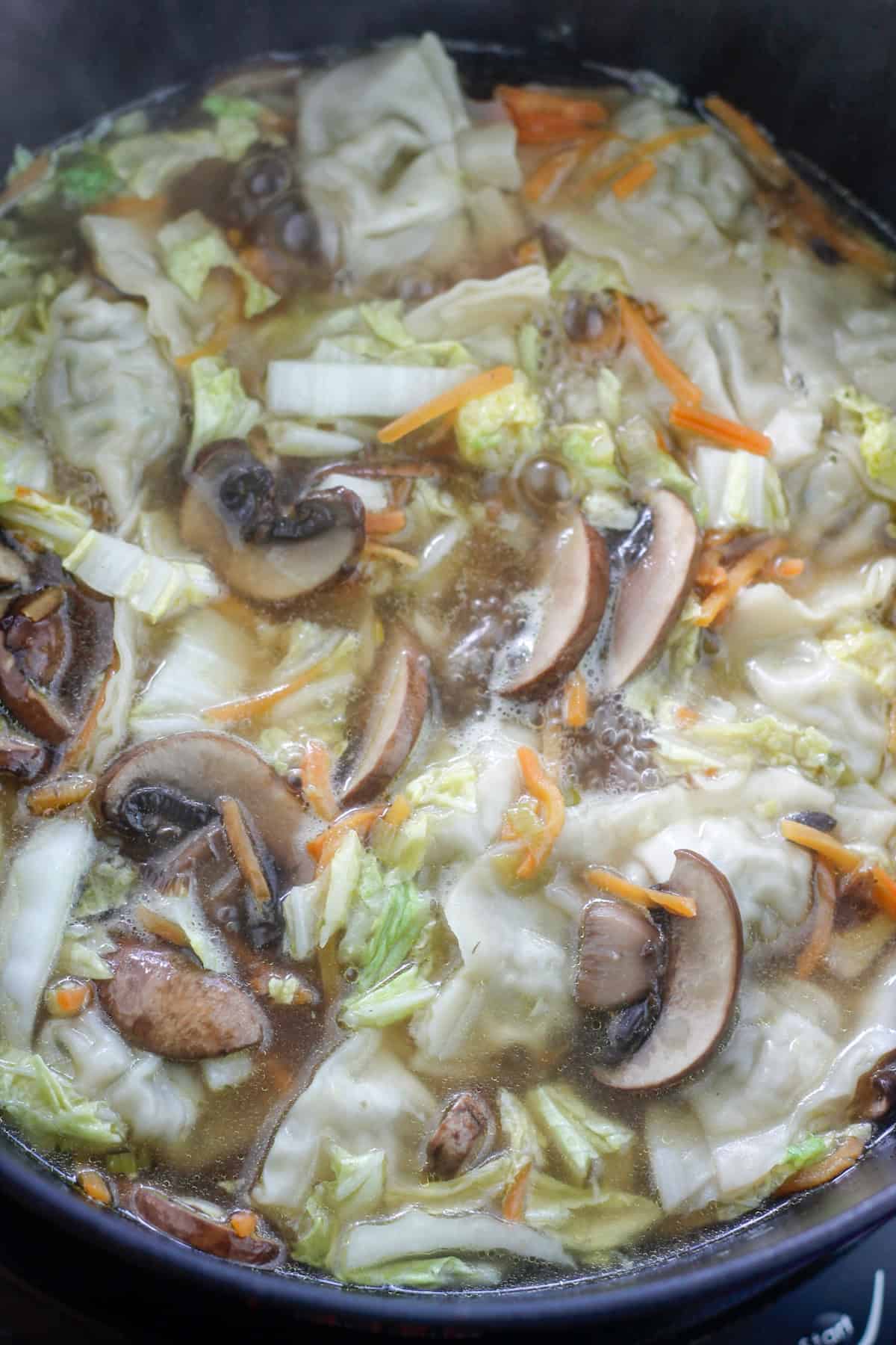 Potsticker soup simmering in a dutch oven.