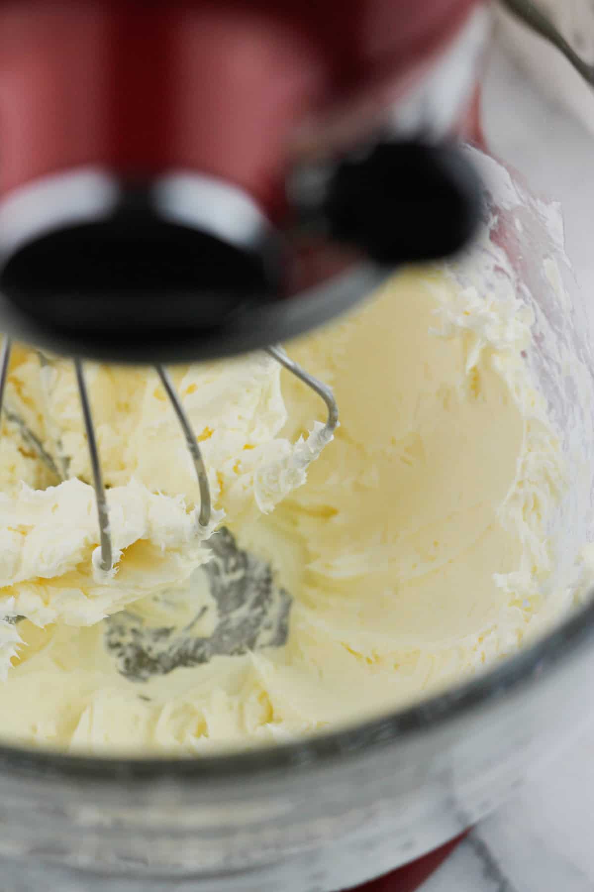 Brown sugar cream cheese frosting whipped in a stand mixer glass bowl.