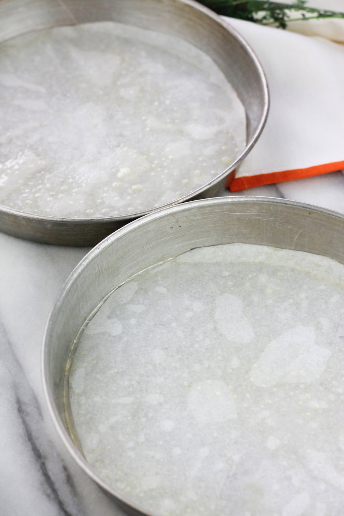 Two cake pans lined with parchment paper.