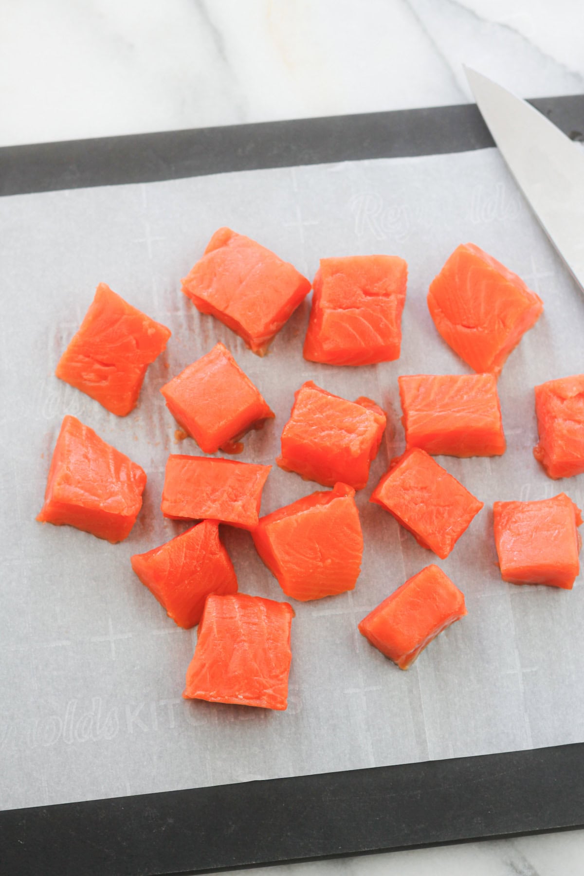 Cubed salmon bites on cutting board.