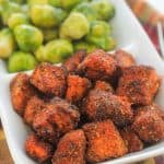 A plate of food with brussels sprouts and fried chicken.