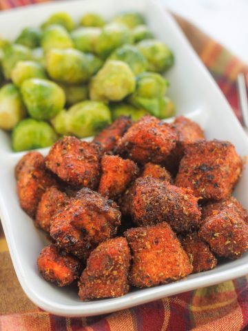 A plate of food with brussels sprouts and fried chicken.