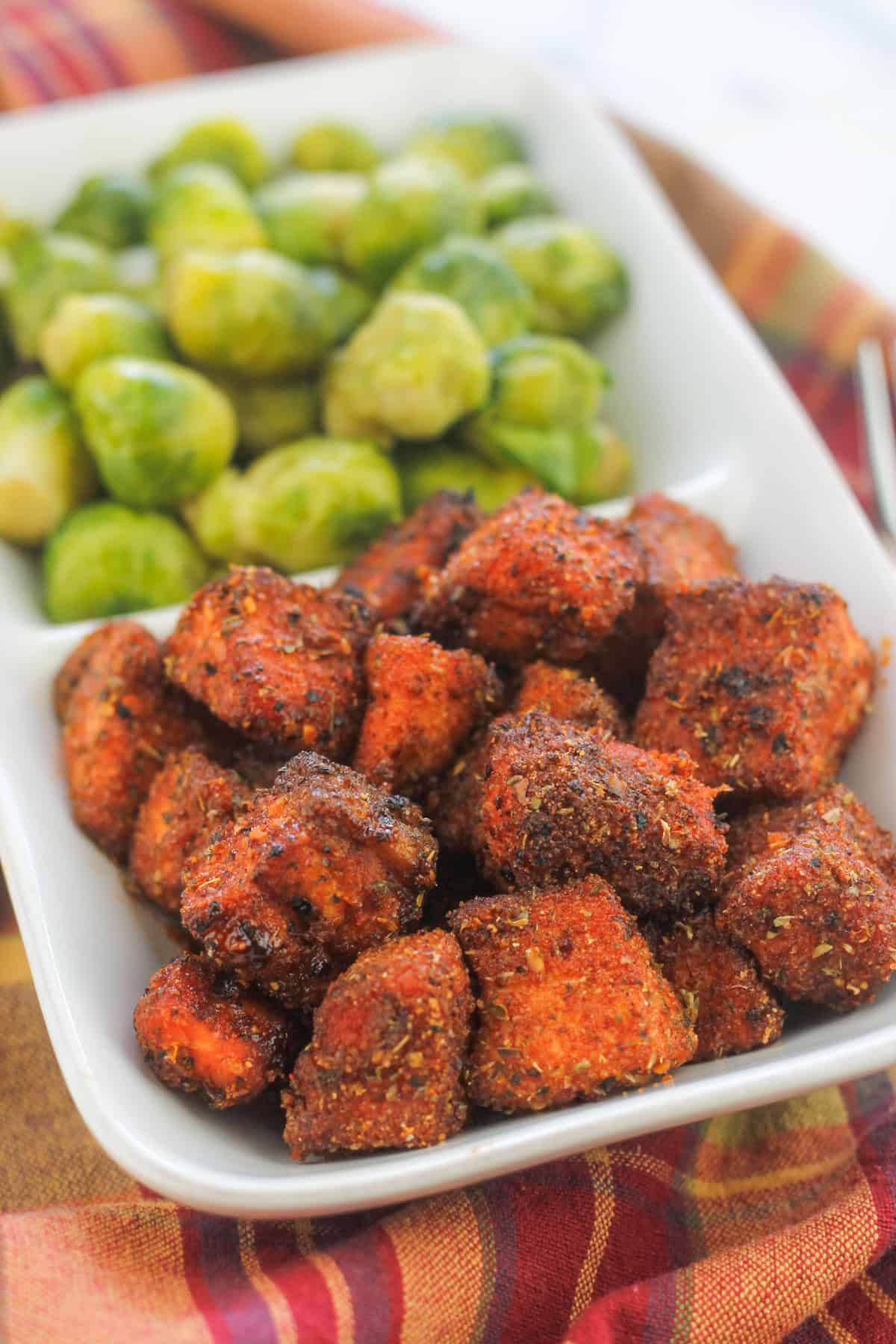 A plate of food with brussels sprouts and fried chicken.