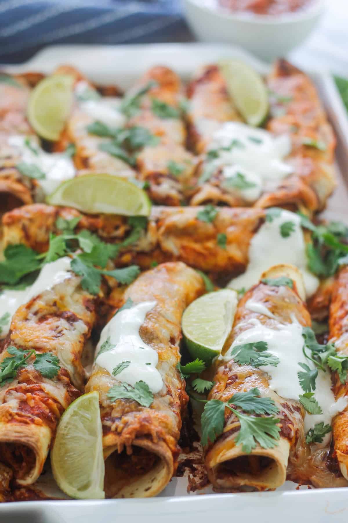 Close-up of a platter of baked chipotle chicken taquitos.