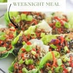 Platter of Low-Carb Asian-Style Ground Meat Lettuce Wraps garnished with sliced green onions, toasted sesame seeds and sriracha.