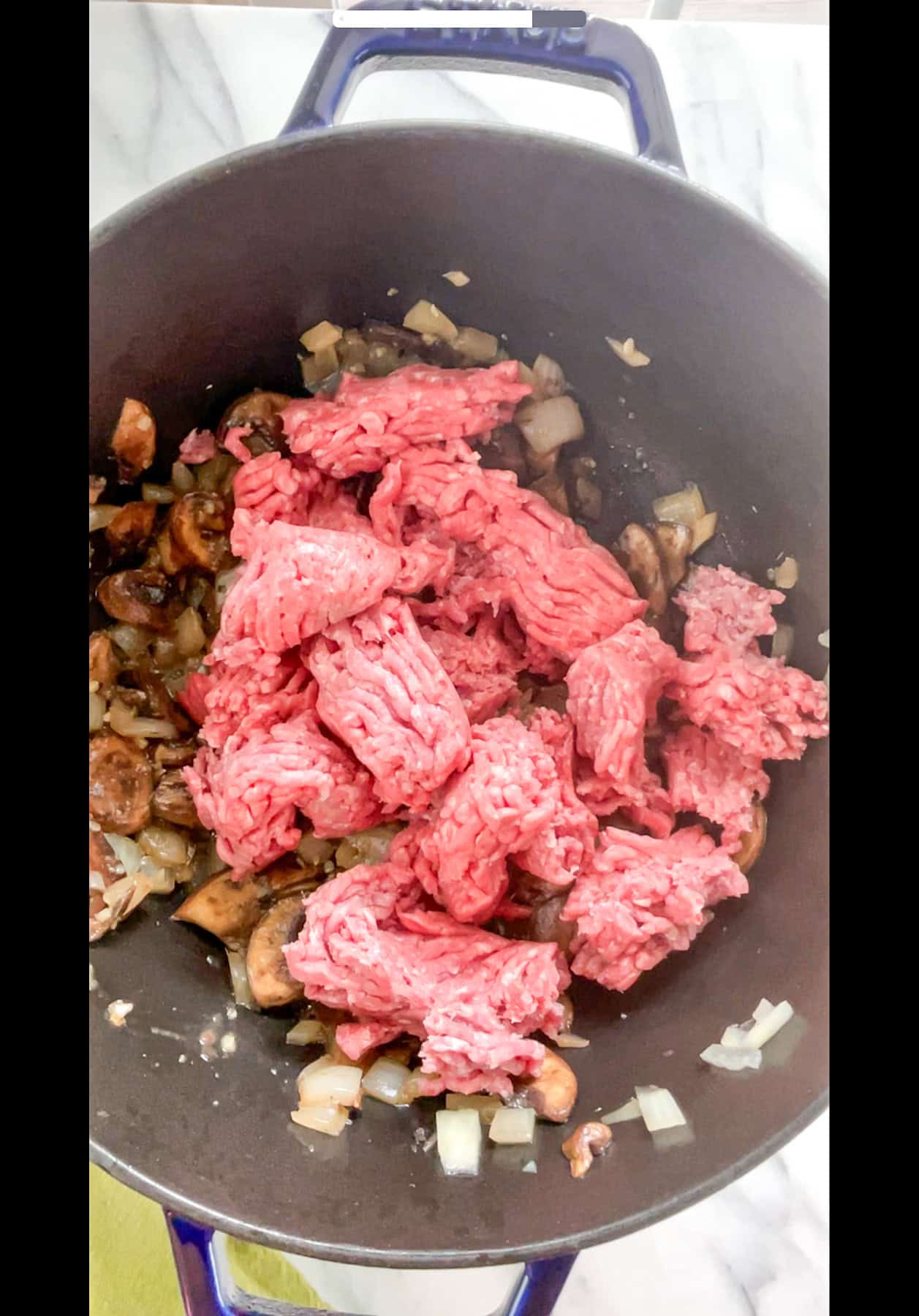 Ground meat added to pan with sautéed mushrooms and onions.