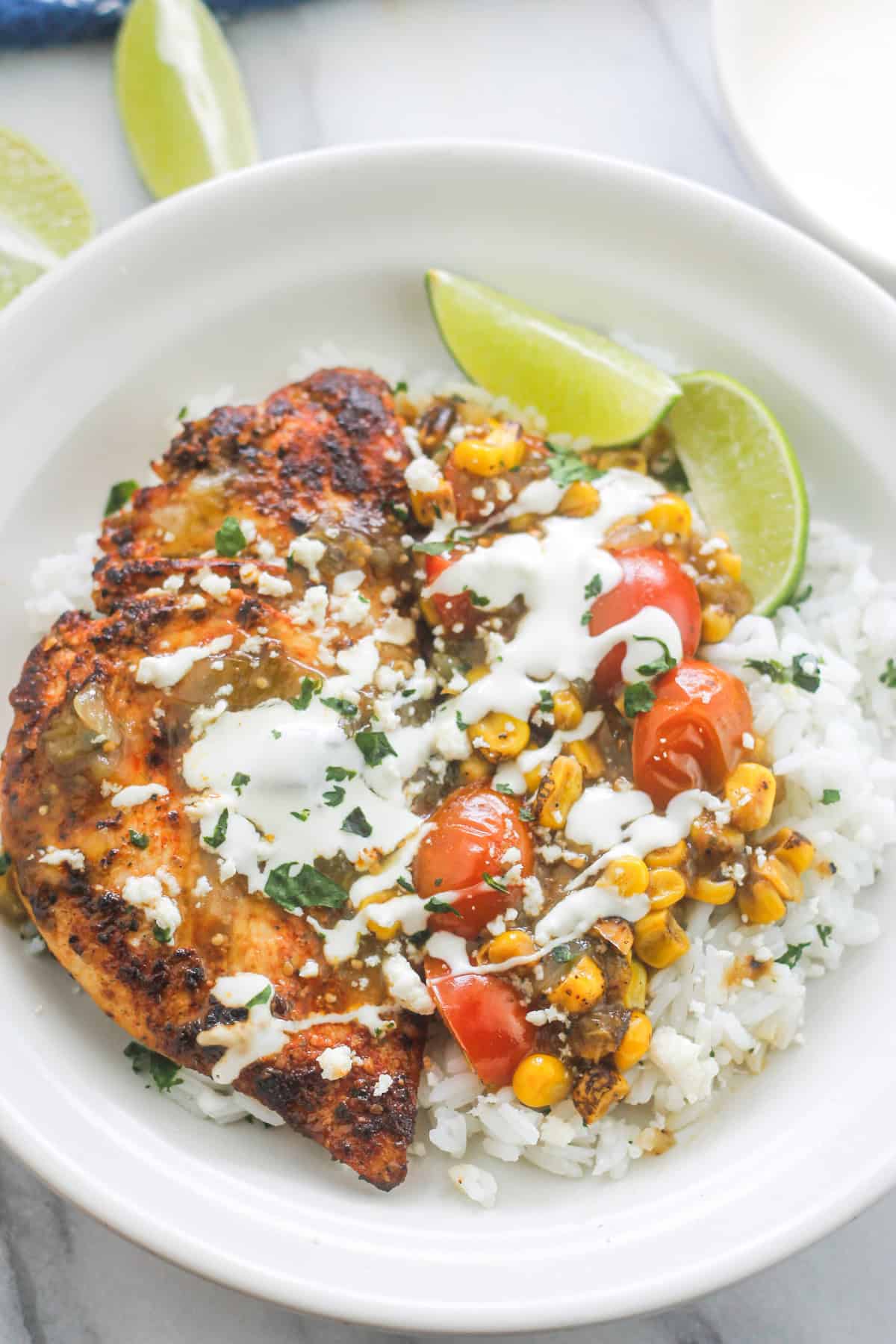 Cilantro lime chicken over cilantro lime rice drizzled with salsa verde sauce and sour cream.