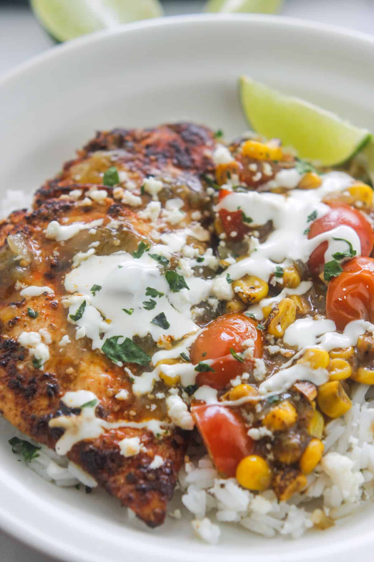 Cilantro lime chicken over cilantro lime rice drizzled with salsa verde sauce and sour cream.