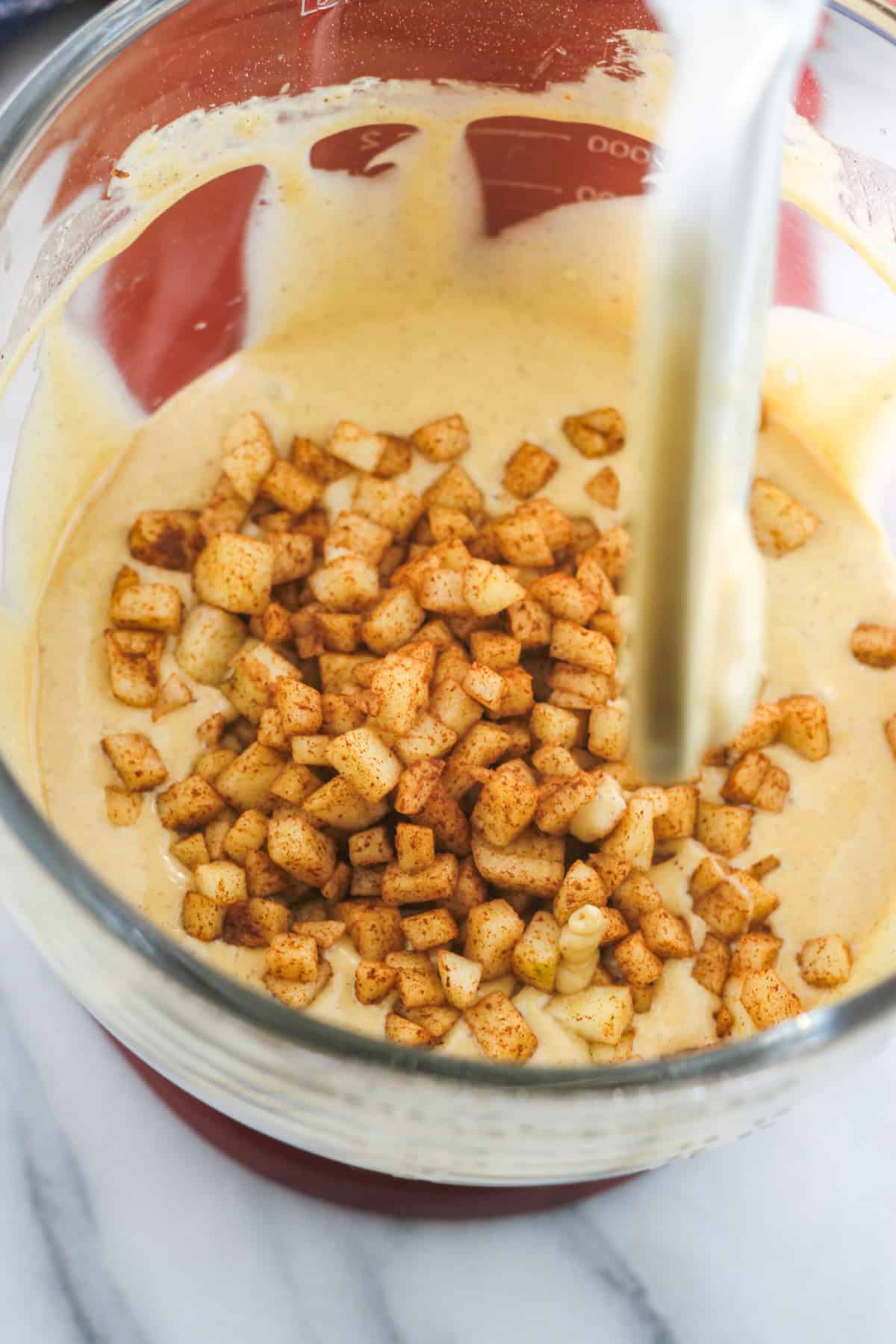 Diced apples tossed with cinnamon added to apple cider cupcake batter.