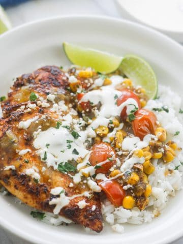 Cilantro lime chicken over cilantro lime rice drizzled with salsa verde sauce and sour cream.