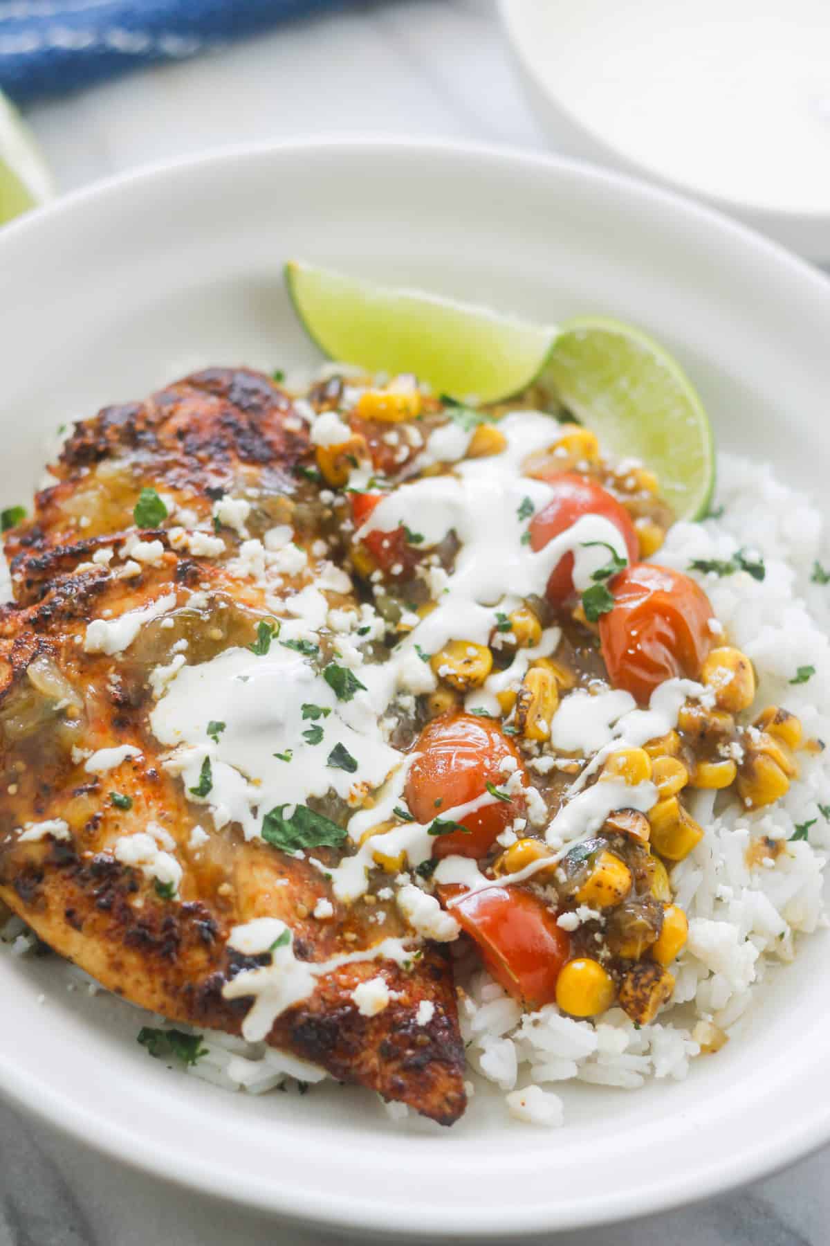 Cilantro lime chicken over cilantro lime rice drizzled with salsa verde sauce and sour cream.