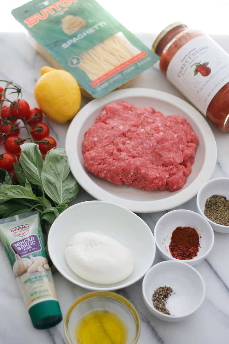 Overhead shot of ingredients used for Beefy Pasta with tomatoes and burrata.