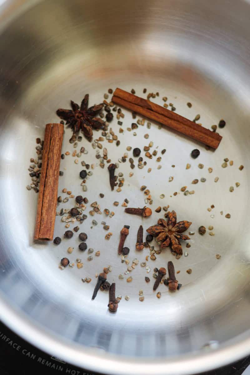 Aromatic spices toasting in a saucepan.