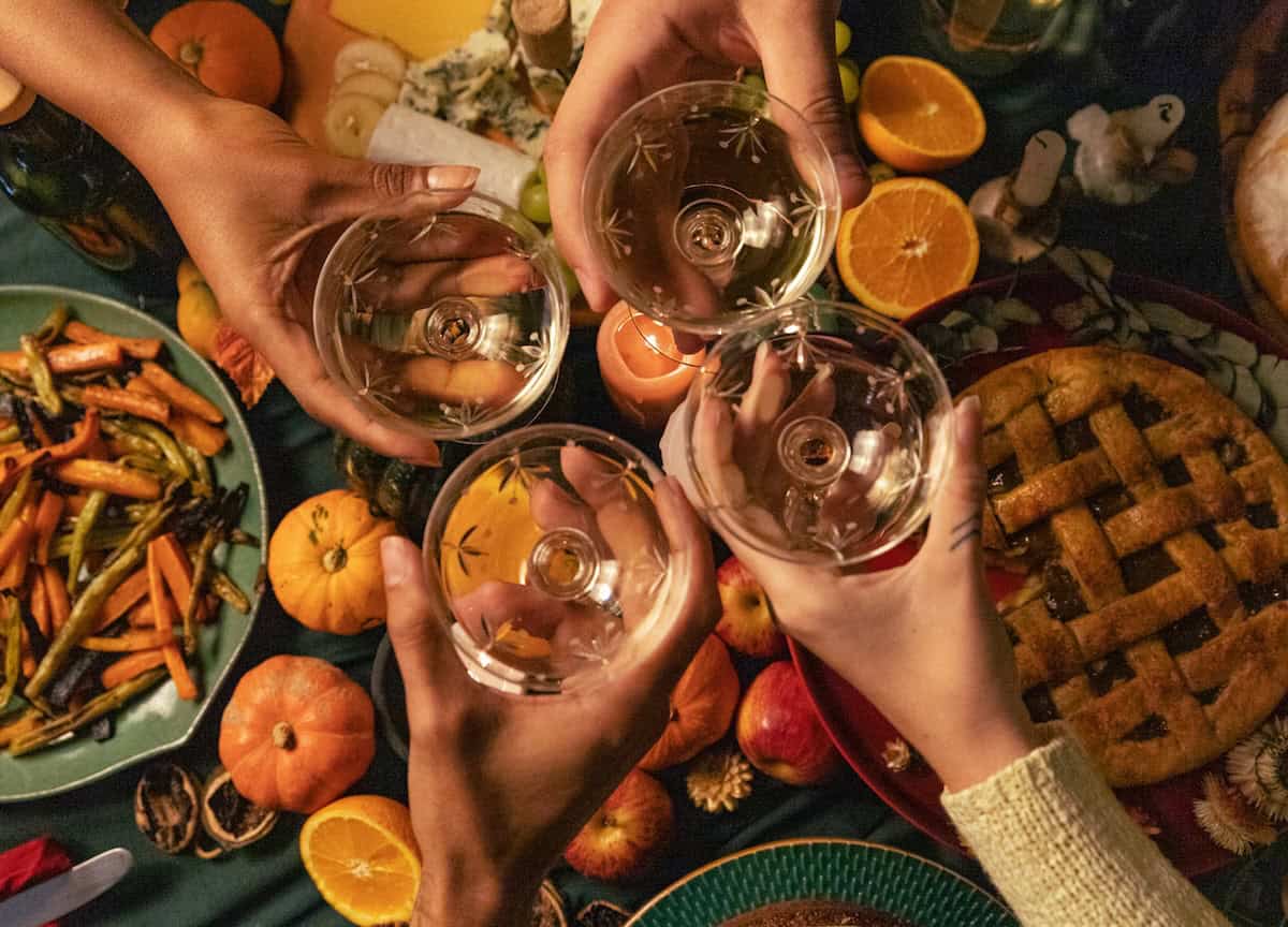 Overhead shot of hands holding drinks at the dinner table.